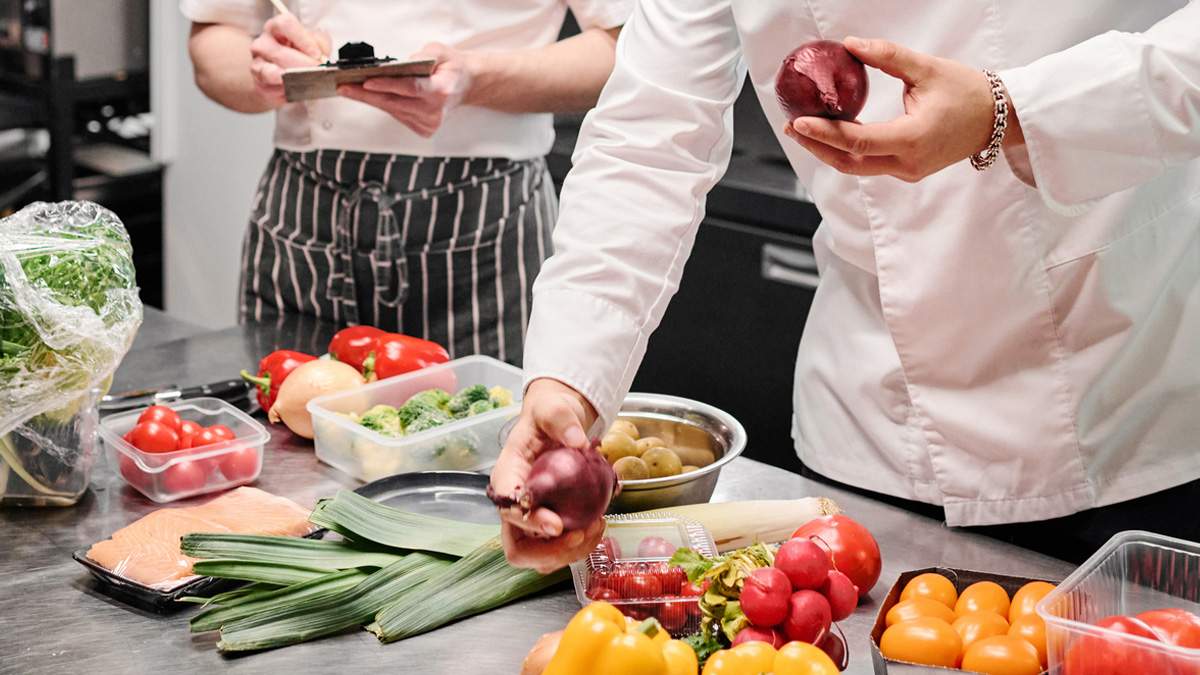 Close up of a counter of various produce that a chef is using to prepare a meal